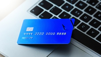 carta di credito appesa a un amo sopro pc portatile